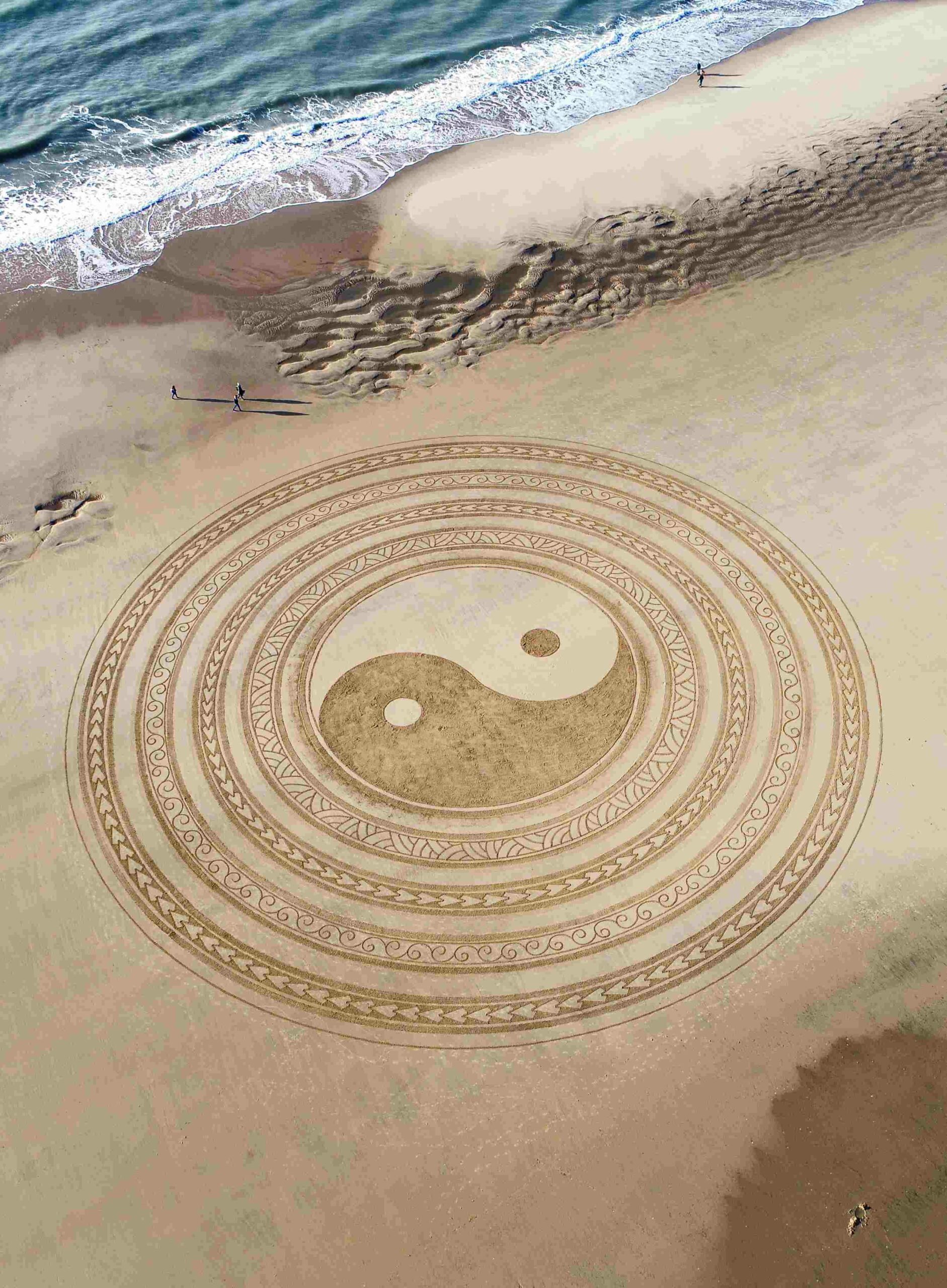 Symbole du Yin et du Yang dessiné dans le sable sur une plage vu du ciel